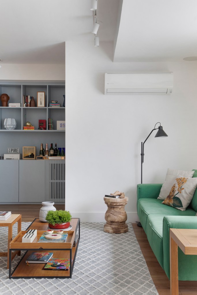 ape-170m-decoracao-inspirada-natureza-lavabo-tropical-cristina-bezamat-fotos-denilson-machado-03-sala-sofa-verde-tapete Sala de estar; sofá verde; estante com nichos; luminária de piso; mesa de centro