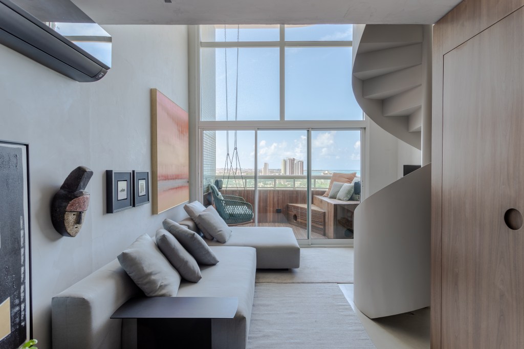 Escada helicoidal e paleta de cinzas marcam cobertura dúplex de 55m²