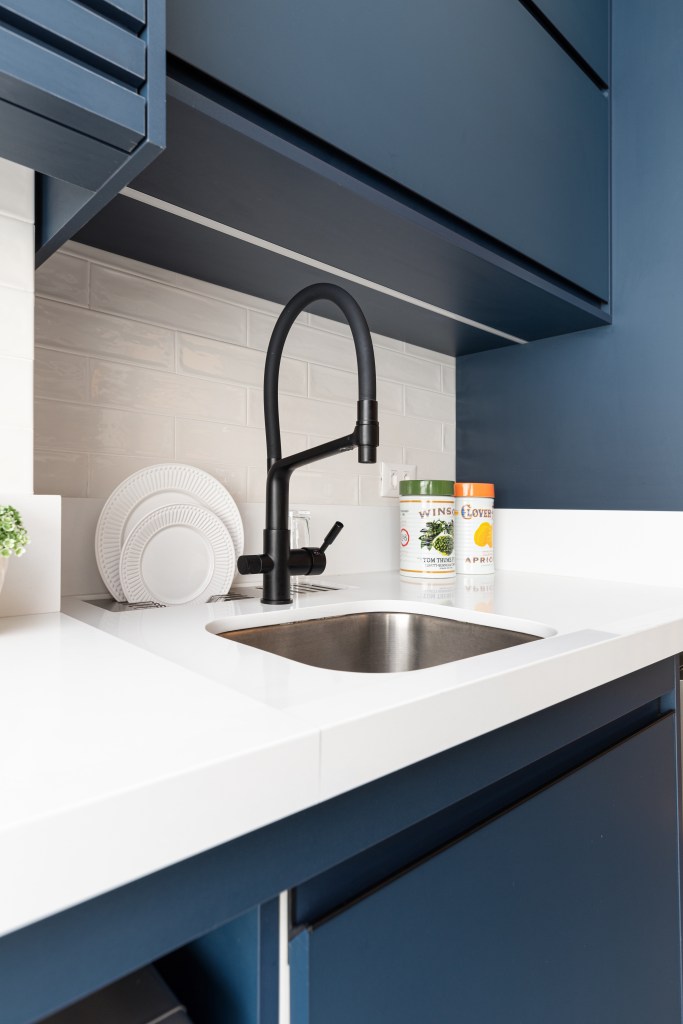 cozinha-protagonista-ape-66m-atmosfera-industrial-cadda-arquitetura-08-cozinha-bancada Bancada branca de cozinha com marcenaria azul.