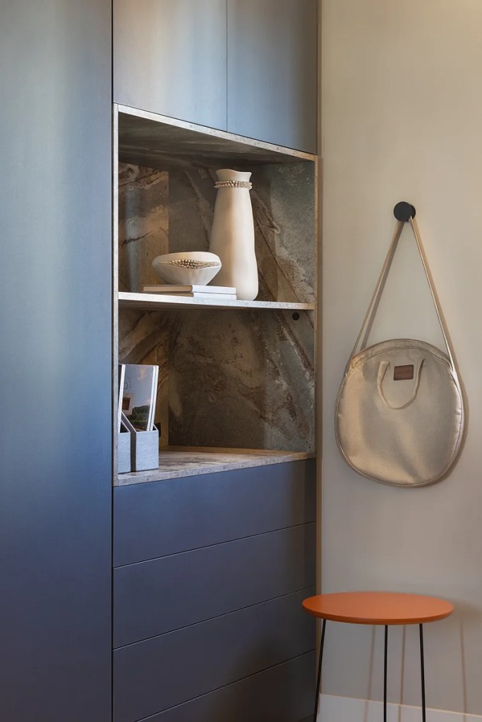 ganchos-cabideiros-na-decoracao-geovani-capelina-arquitetura-02 Home office com marcenaria e poltrona azul e gancho na parede.