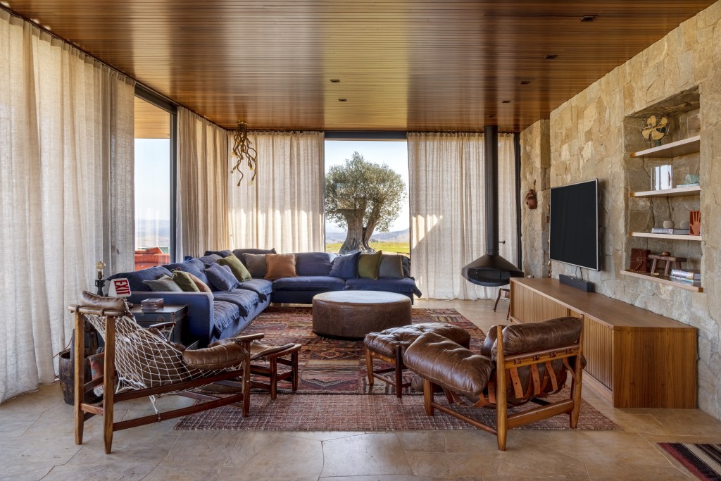 rancho sustentável Bruno Gagliasso Giovanna Ewbank Hana Lerner decoracao sala estar living pedra quadro poltrona lareira tapete sofa