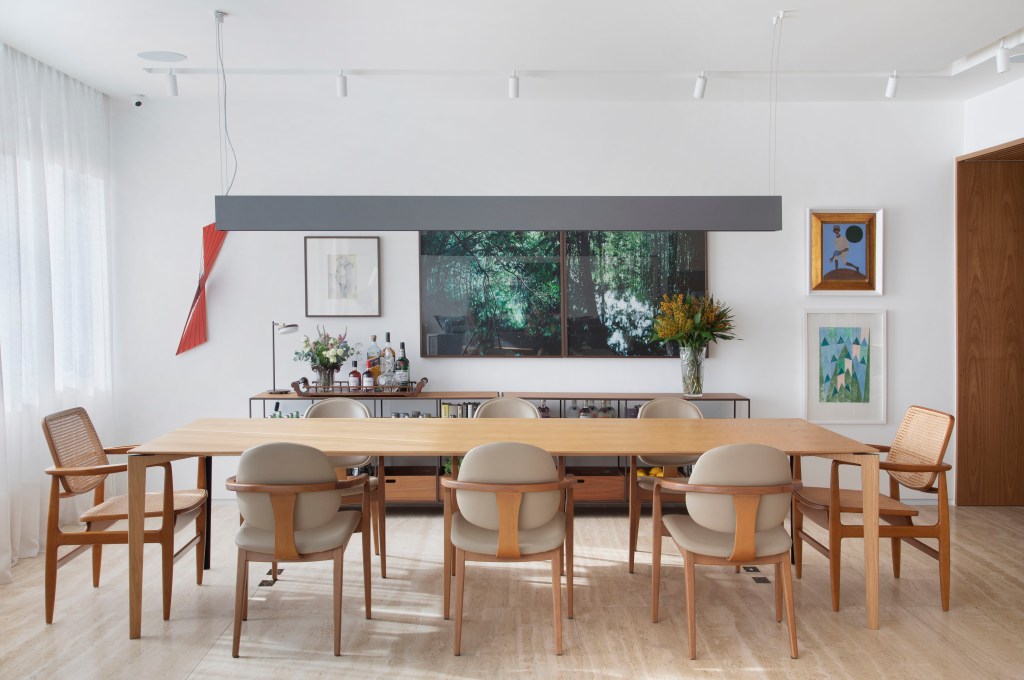 Sala de jantar com mesa de madeira e cadeiras de madeira.