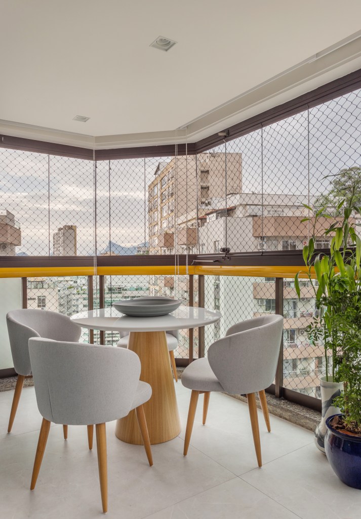 cobertura-estilo-urbano-no-primeiro-andar-e-praiano-no-segundo-nop-arquitetura-13-varanda Varanda integrada fechada com vidro com mesa redonda pequena.