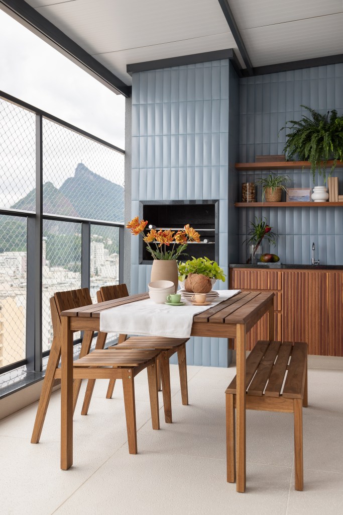 cobertura-leve-140m-area-social-integrada-varanda-gourmet-maia-romeiro-arquitetura-08 Área gourmet; varanda gourmet com churrasqueira, mesa de madeira e parede revestida de azulejos azuis.