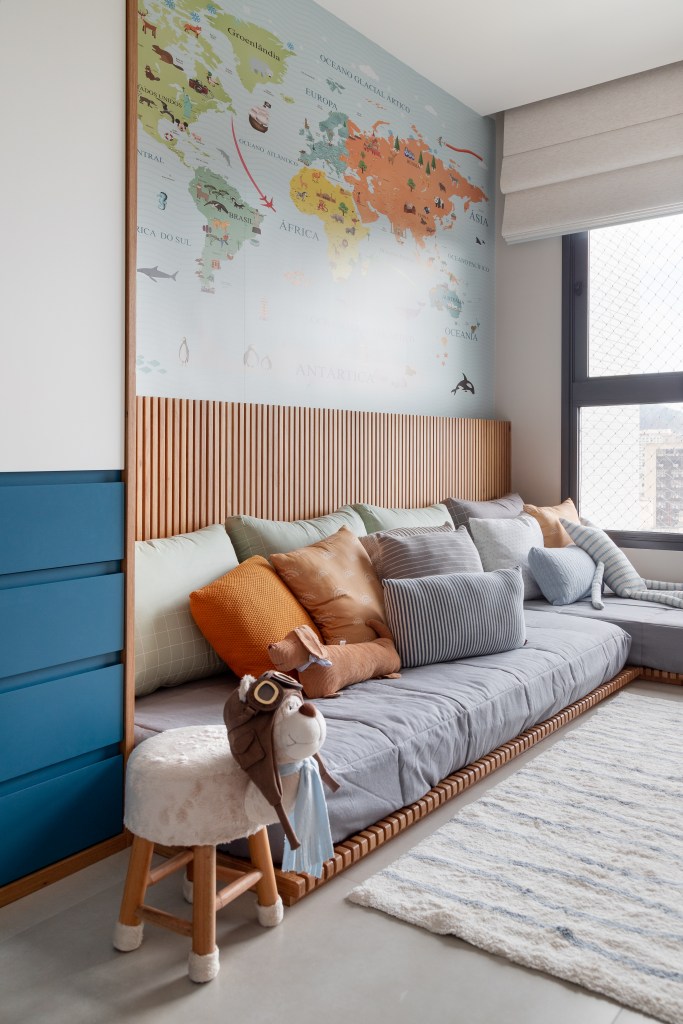 cobertura-leve-140m-area-social-integrada-varanda-gourmet-maia-romeiro-arquitetura-22-quarto-infantil Quarto infantil com cama baixa, papel de parede de mapa e painel ripado.