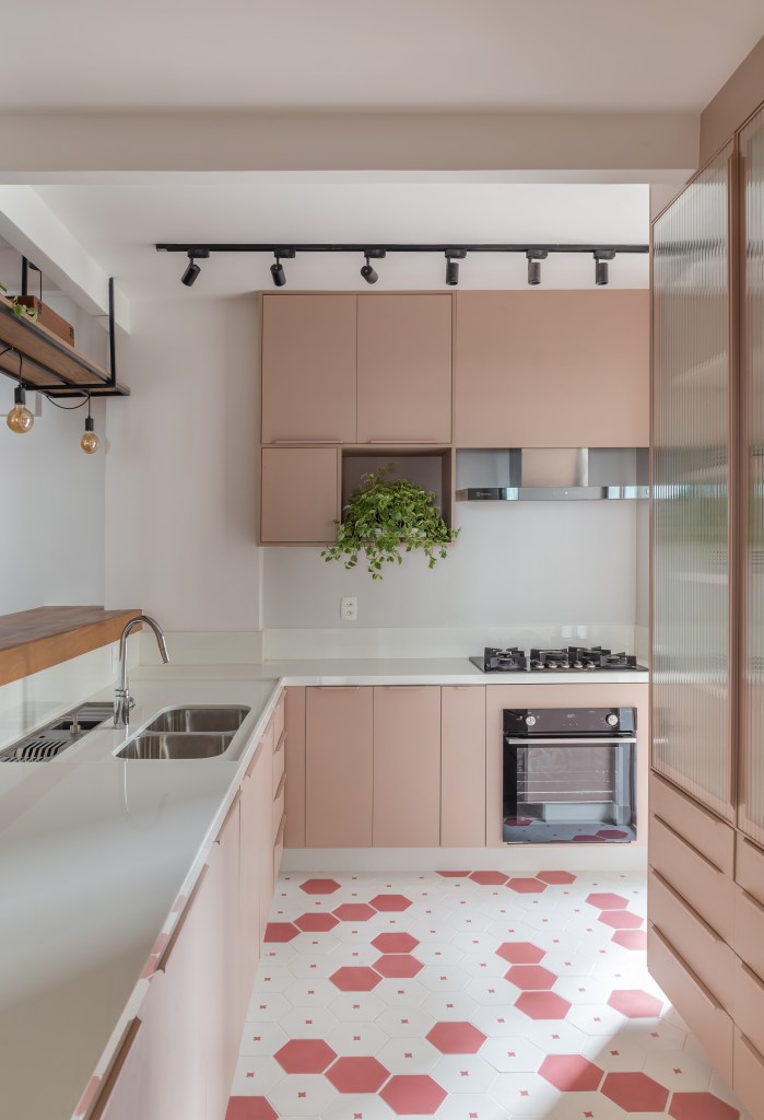 ladrilhos-moveis-madeira-toque-retro-ape-145m-casa-ninho-estudio-10-cozinha-rosa Cozinha com marcenaria rosa, bancada branca e piso em ladrilho hidráulico.