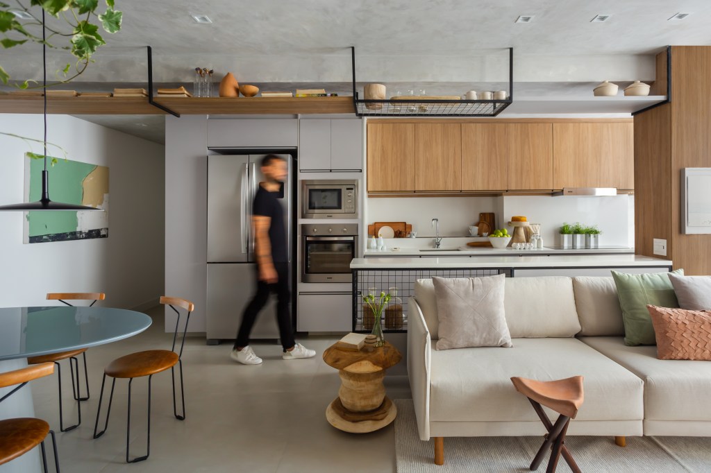 portas-correr-vidro-canelado-home-office-ape-95m-rafael-ramos-09 Cozinha americana; Sala integrada com cozinha com piso de porcelanato e sofá branco.