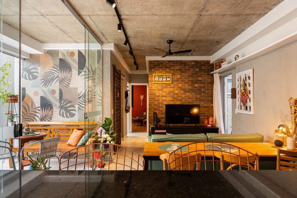 ape-120m-sofa-verde-tijolinho-porcelanato-varanda-spa-grupo-arquitetos-urbanistas-07 Sala de estar com cozinha de bancada preta e sala de estar com sofá verde e parede de tijolinhos de porcelanato.