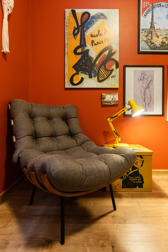 ape-120m-sofa-verde-tijolinho-porcelanato-varanda-spa-grupo-arquitetos-urbanistas-16-cantinho-leitura-poltrona Home office; cantinho de leitura com parede vermelha e poltrona costela cinza.
