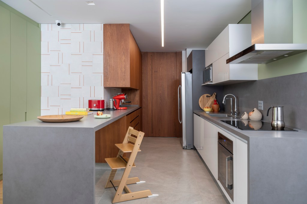 mesa-concreto-varanda-gourmet-ape-270m-raizes-arquitetos-05 Cozinha com marcenaria branca e bancada cinza.