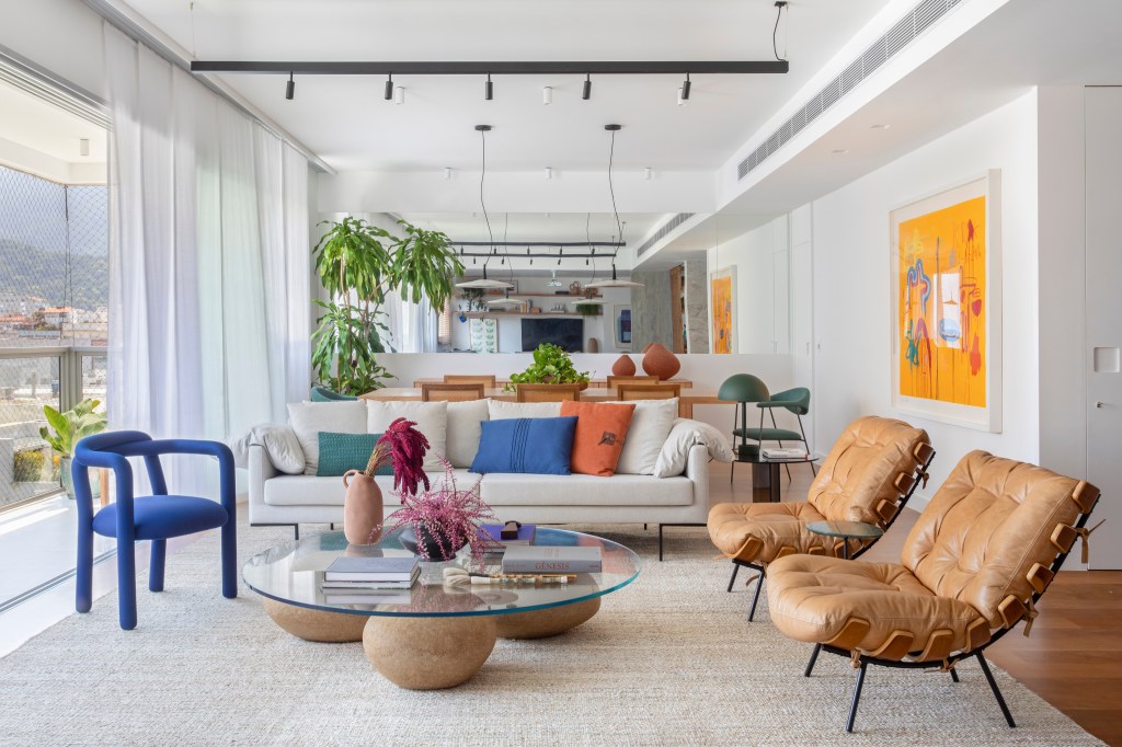 Apê de 190m² ganha área de copa com parede azul e cadeiras alaranjadas