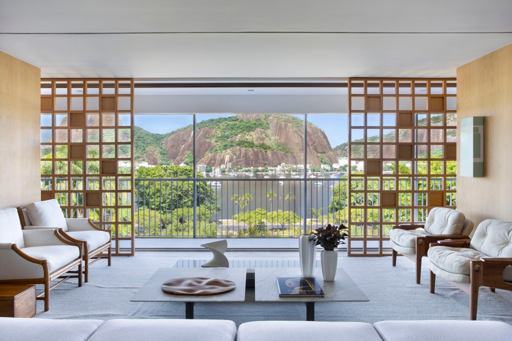 Painel vazado de madeira emoldura a paisagem em apê de 400m²