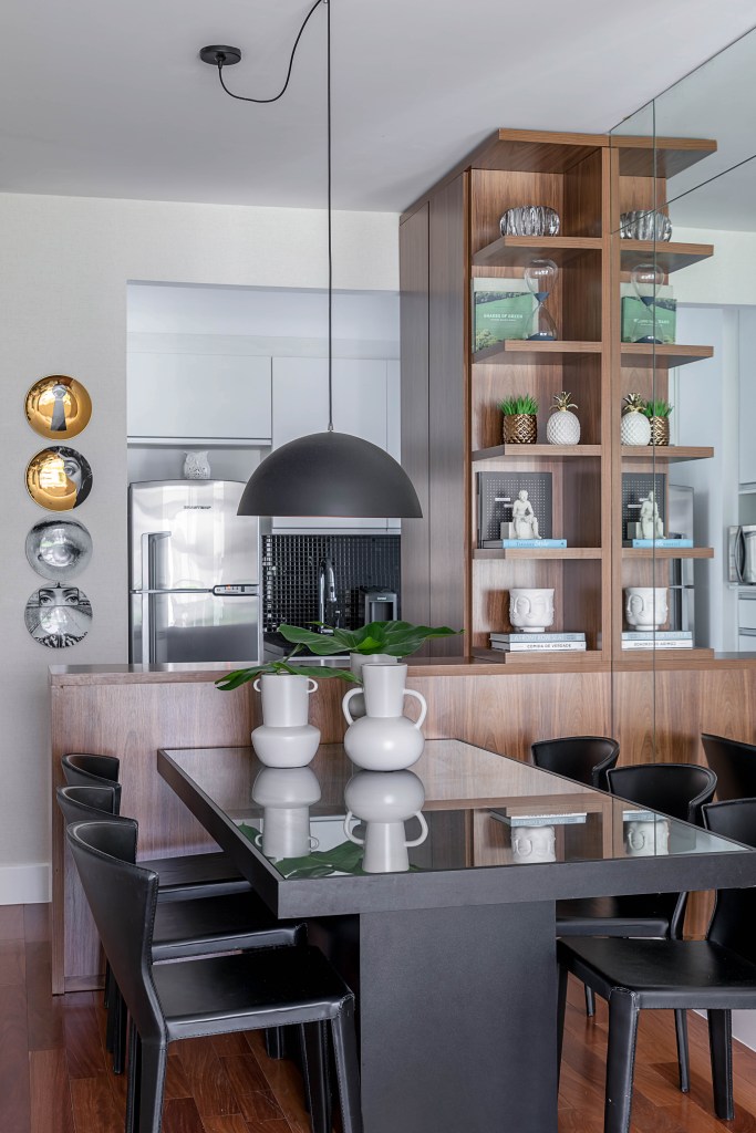 solucoes-camufladas-estilo-decor-carina-dal-fabbro-08 Sala de jantar integrada com cozinha; estante em marcenaria escura que funciona como divisão e bancada entre os dois ambientes.