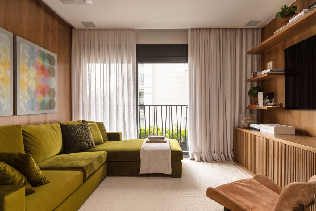 Projeto de Denise Polverini e Fernanda Villefort. Na foto, sala de estar com tapete bege e sofá verde.