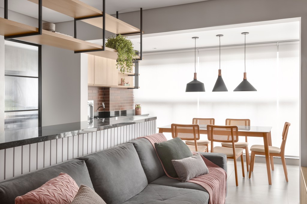 Apê de 84 m² ganha décor delicado em tons de azul, verde e rosa. Projeto de Dani Espírito Santo. Na foto, varanda gourmet com mesa de jantar, cozinha e sala integrada.