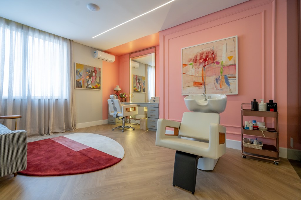 casa-785m-digital-influencer-salao-de-beleza-rosa-romario-rodrigues-arquitetos-20 Projeto de Romário Rodrigues Arquitetos. Na foto, salão de beleza rosa com boiseries, cadeira branca e espelho com iluminação lateral embutida.
