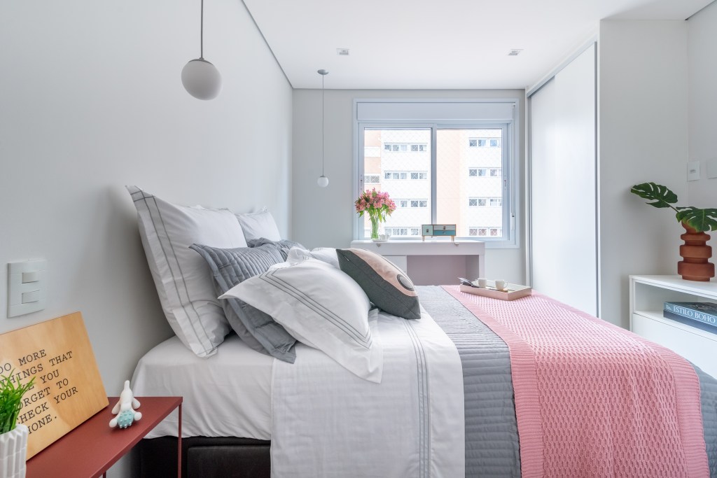 quarto-servico-vira-home-office-integrado-ao-quarto-ape-isabella-nalon-15 Projeto de Isabella Nalon. Na foto, quarto com cama de casal e armário branco com espelho na porta.