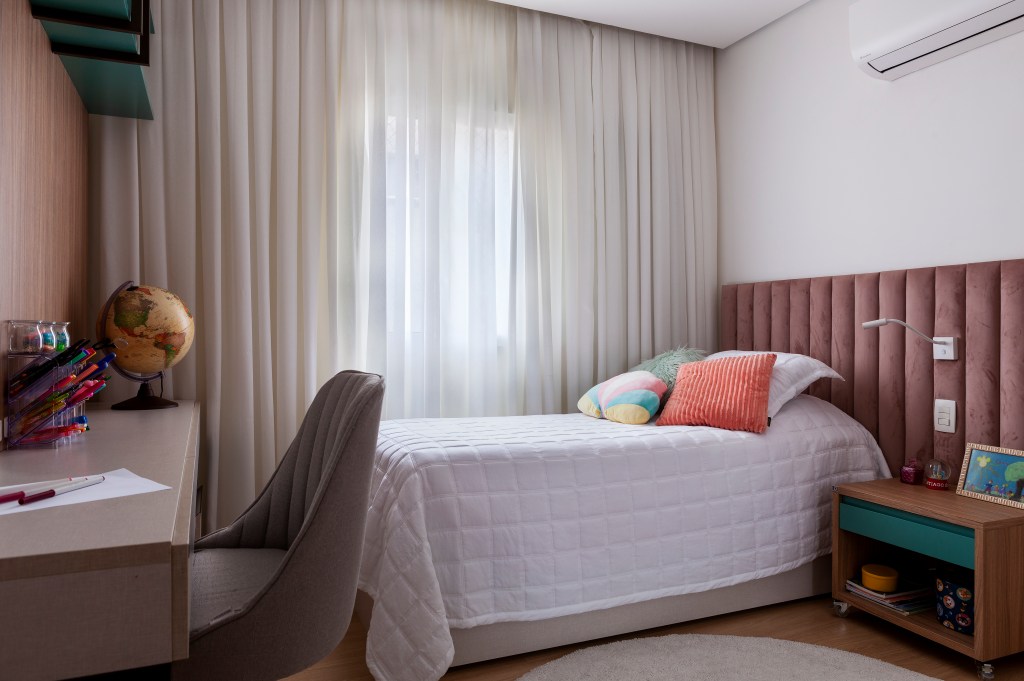 revestimentos-tateis-recursos-sensoriais-ape-acessivel-130m-infinity-spaces-05 Quarto infantil com cama de solteiro, cabeceira acolchoada, bancada de estudos e cortina.