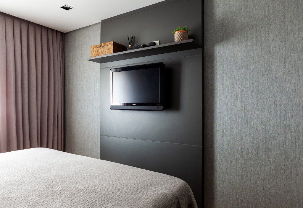 revestimentos-tateis-recursos-sensoriais-ape-acessivel-130m-infinity-spaces-11 Quarto com painel em marcenaria preta para tv.