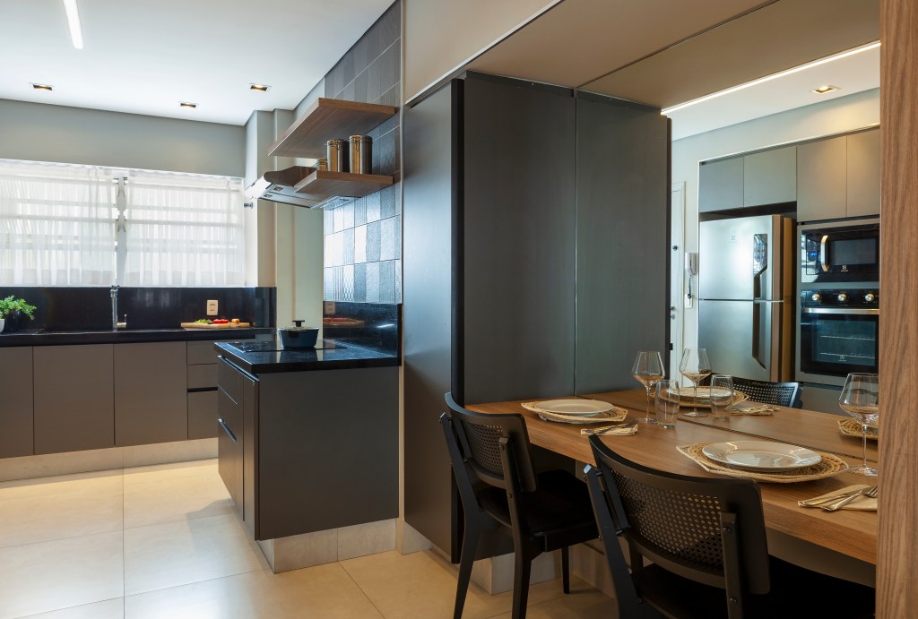 revestimentos-tateis-recursos-sensoriais-ape-acessivel-130m-infinity-spaces-12 Cozinha com copa de refeições, piso de porcelanato, marcenaria cinza.
