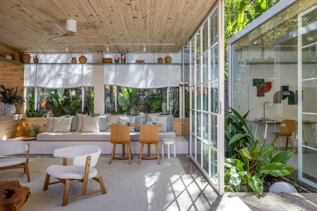 tres-conteineres-cafe-e-livraria-mauricio-nobrega-casacor-rio-2023-14 Quintal - ambiente de Maurício Nóbrega para a CASACOR Rio 2023. Café com poltronas brancas e sofá em cores claras.