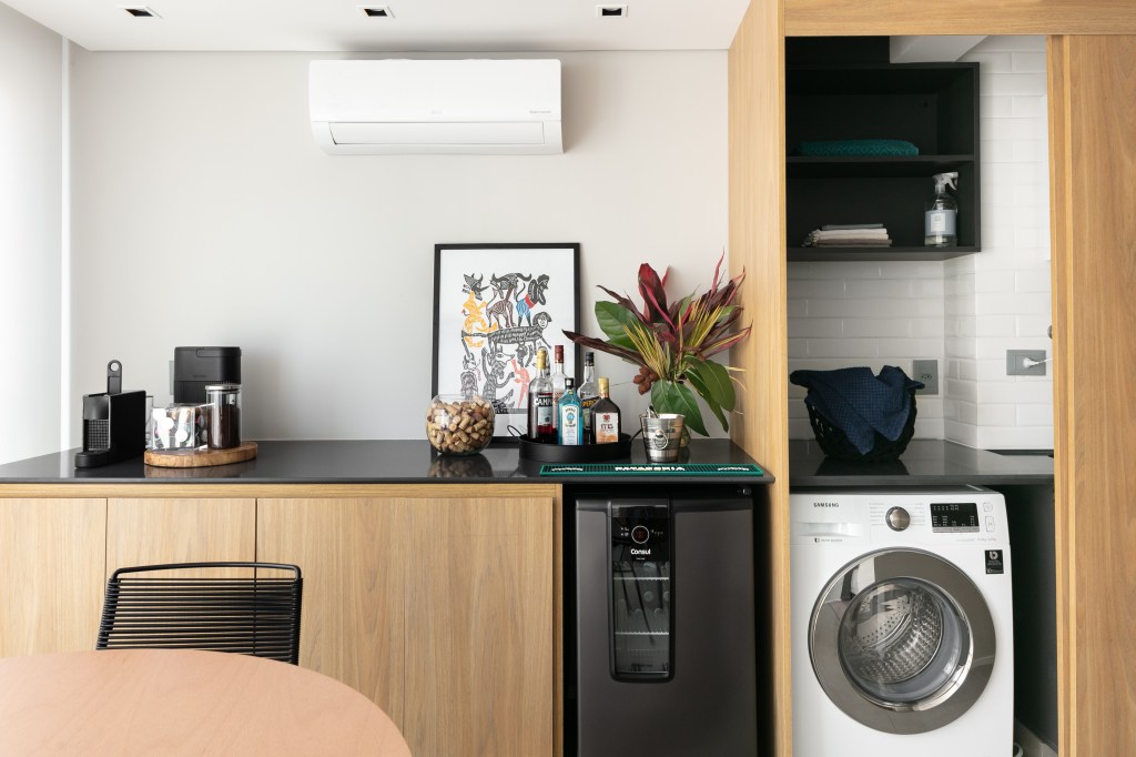 Apê de 60m² ganha cozinha integrada e lavanderia camuflada na marcenaria