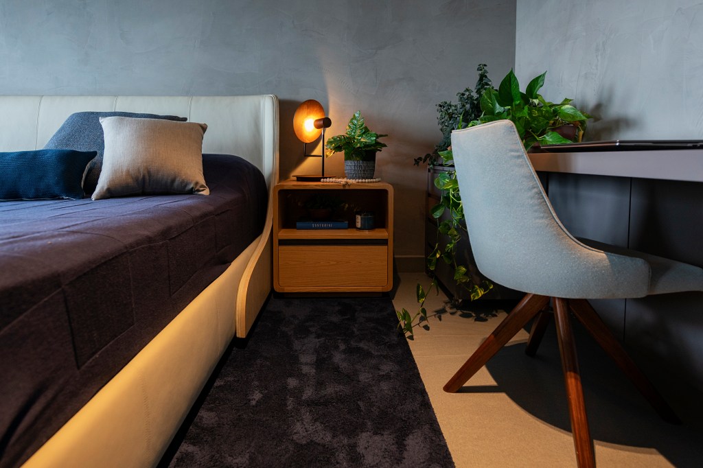 qual-iluminacao-perfeita-quarto-projeto-pietro-terlizzi Qual é a iluminação perfeita para deixar o quarto relaxante. Na foto, quarto com home office, tapete e luminária ao lado da cama.