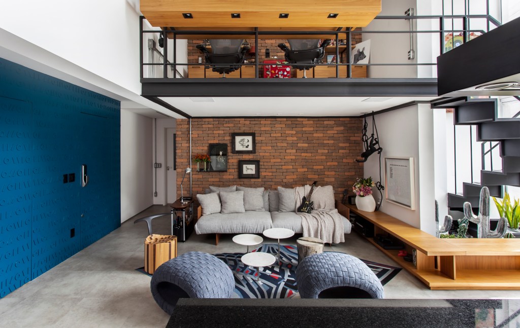 Tijolinhos revestem loft de 100m² industrial com home office no mezanino