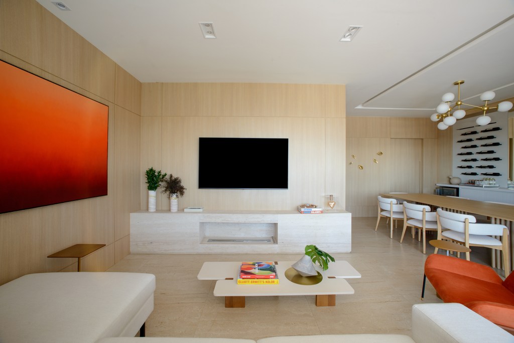 Paredes de madeira e tons de laranja compõem o décor deste apê de 138 m²