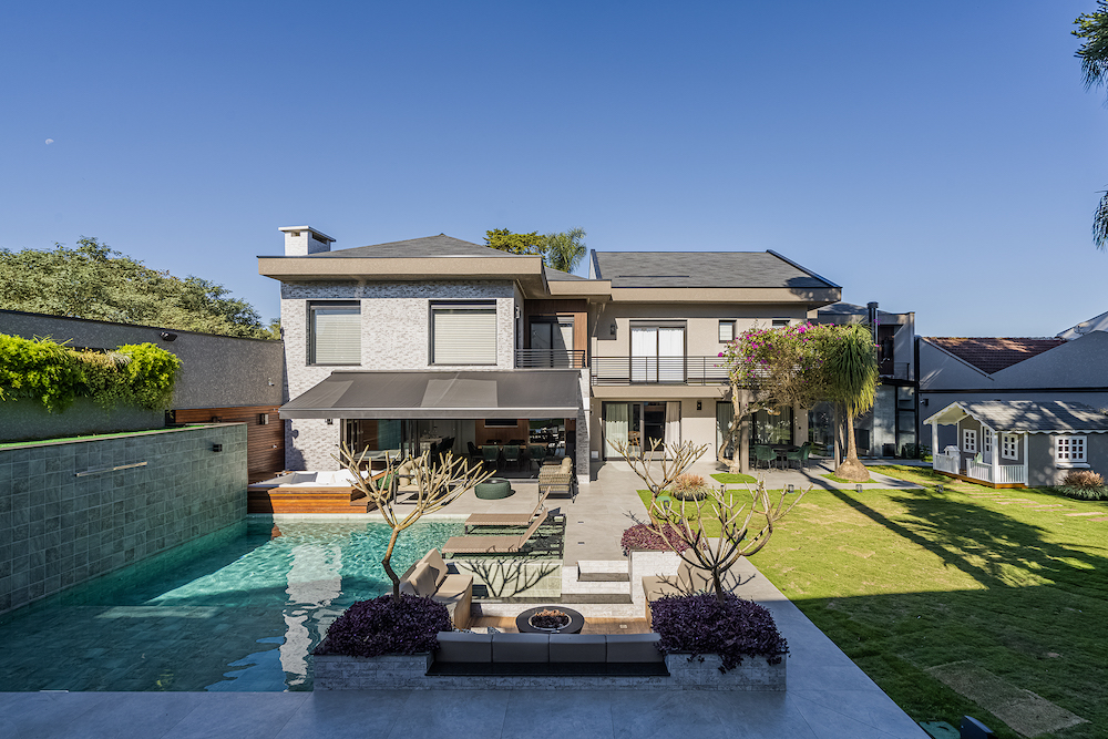 Reforma transforma casa da década de 1970 em uma moradia moderna de 600 m². Projeto de Soraya Surdi. Na foto, fachada com piscina, jardim e hidromassagem.