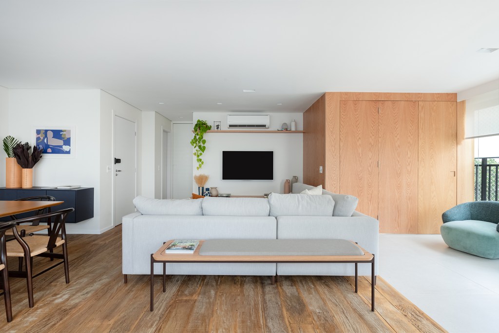 apartamento-147-m2-ambientes-integrados-repletos-luz-natural-estudio-mare-credito-monica-assam (26) Apartamento de 147 m² ganha ambientes integrados e repletos de luz natural. Projeto de Estúdio Maré. Na foto, sala de TV com rack ripado e parede de madeira.