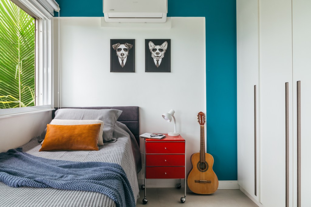 ape-140-m2-parece-casa-meio-arvores-ana-cano-credito-luiza-schreier (10) Apartamento de 140 m² parece uma casa em meio às árvores. Projeto Ana Cano. Na foto, quarto infantil com mesa de cabeceira vermelha e quadros.