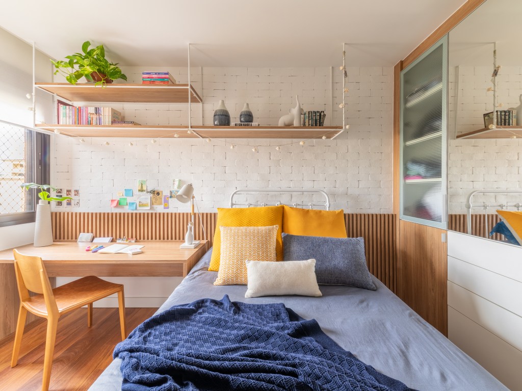 Cozinha integrada com bancada de neolith e cristaleira é destaque em apê. Projeto de Pietro Terlizzi. Na foto, quarto infantil com cabeceira de lambri, bancada para estudos e parede de tijolinhos.