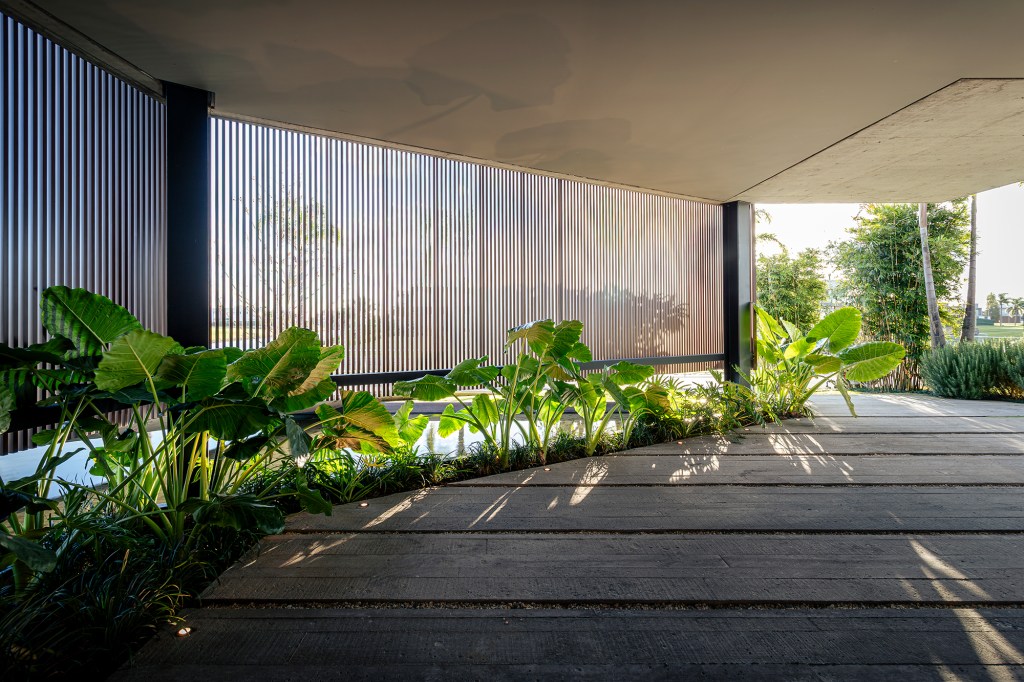 A água é destaque nesta casa de 457 m² no Rio Grande do Sul. Projeto de Stemmer Rodrigues. Na foto, fachada com jardim.