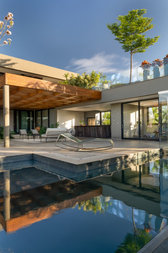 casa-erguida-do-zero-duas-cozinhas-madeira-ripada-rf-arquitetura-09 Casa erguida do zero ganha duas cozinhas e muita madeira ripada. Projeto de RF Arquitetura. Na foto, área externa com piscina, jardim e pergolado.