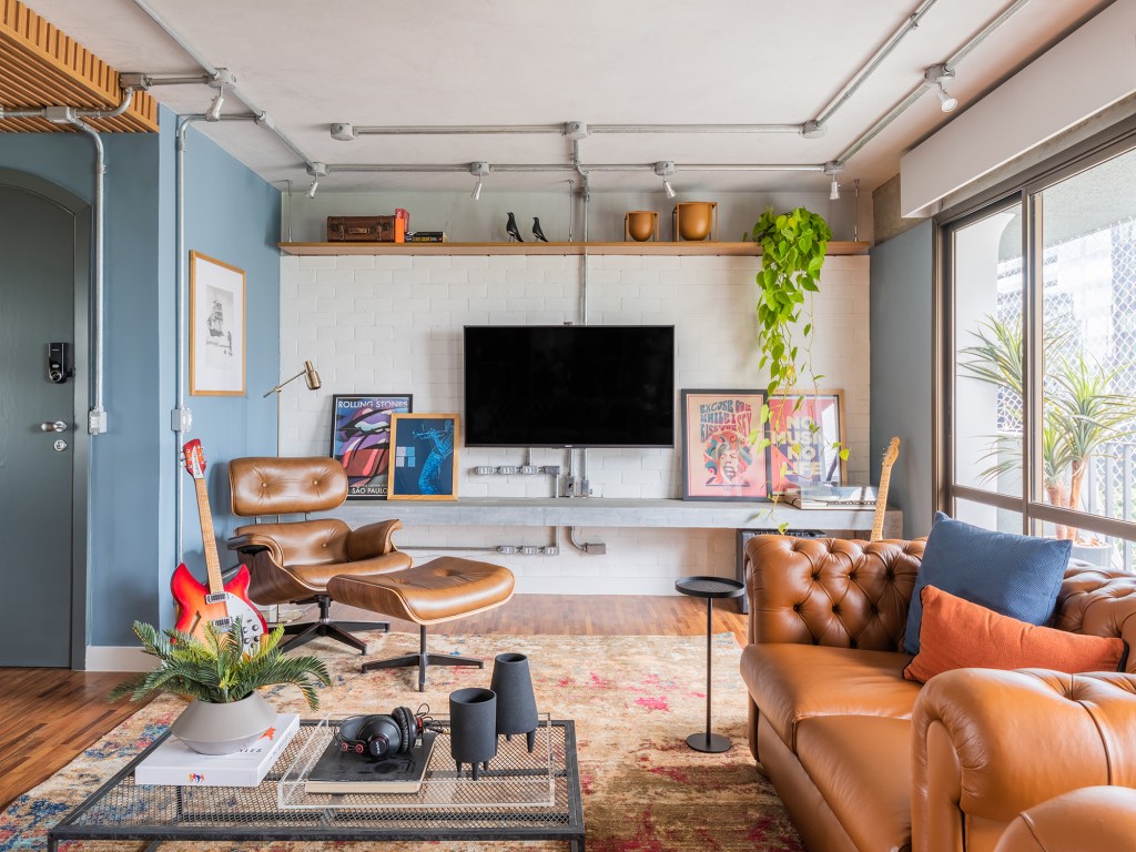 Estilo industrial e elementos clássicos se unem em apartamento de 130 m². Projeto de Pietro Terlizzi. Na foto, sala com tv, parede de tiles e sofá cheestfield.