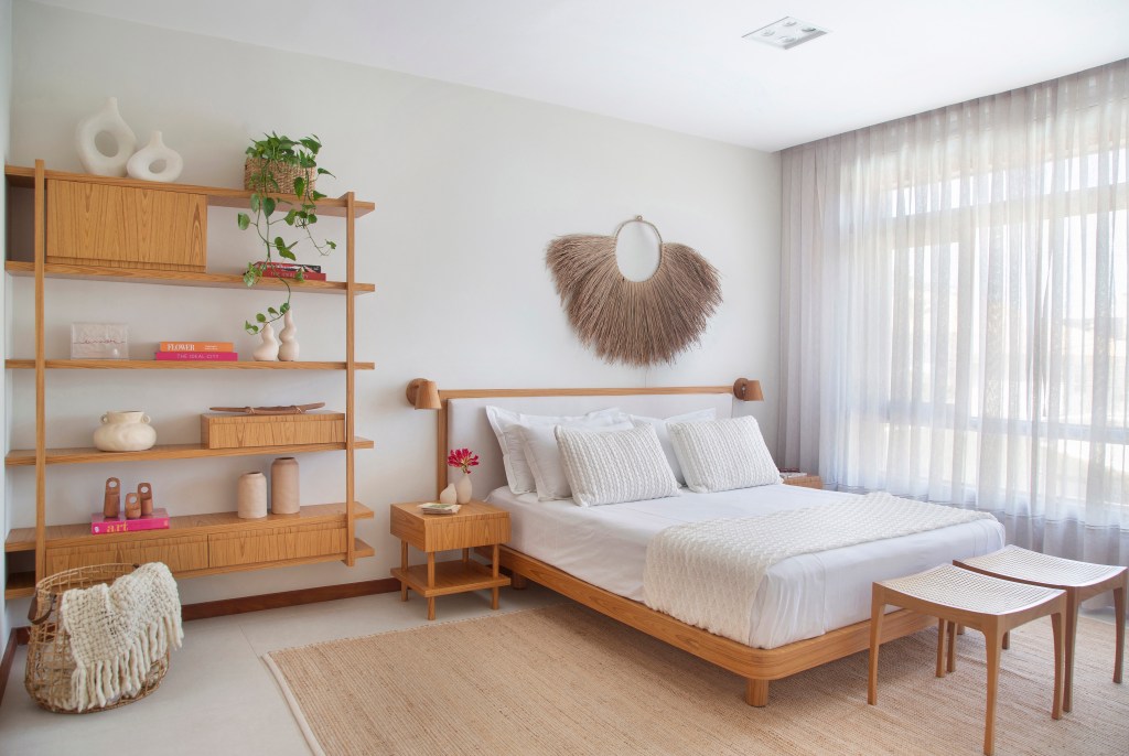 Ilha de cozinha revestida de azulejos com peixes é destaque nesta casa. Projeto de Travessa Arquitetura. Na foto, quarto zen, cama de casal, estante vazada com planta.