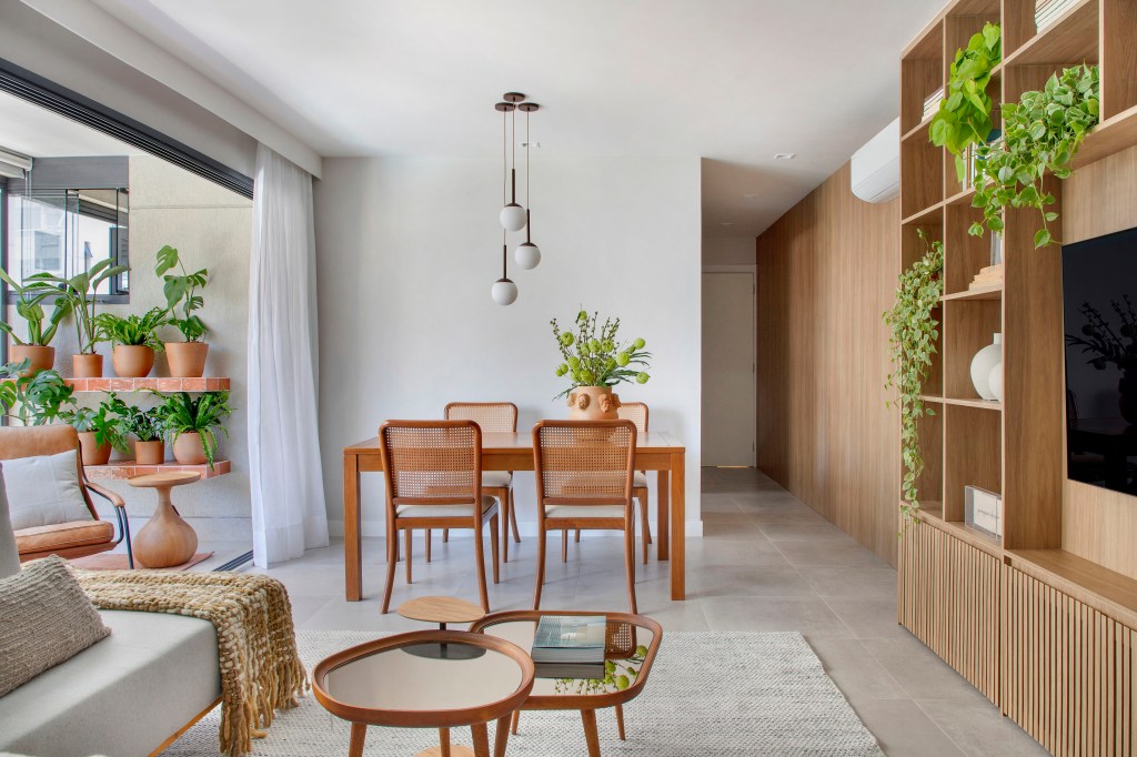 Madeira e tons terracota junto de plantas dão toque mineiro à apê de 92 m²