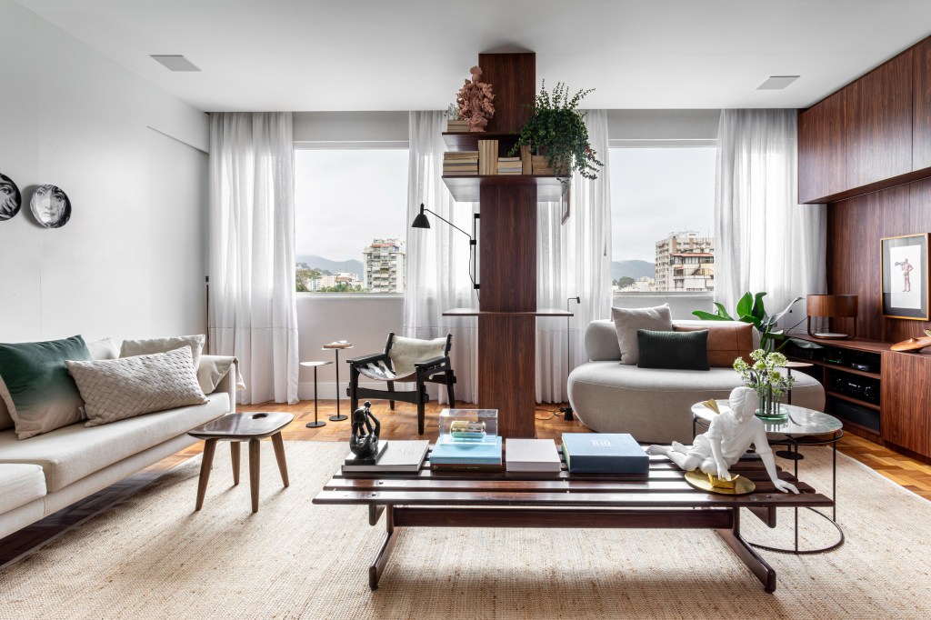 Peças afetivas com memória, design e madeira escura compõem apê de 116 m²