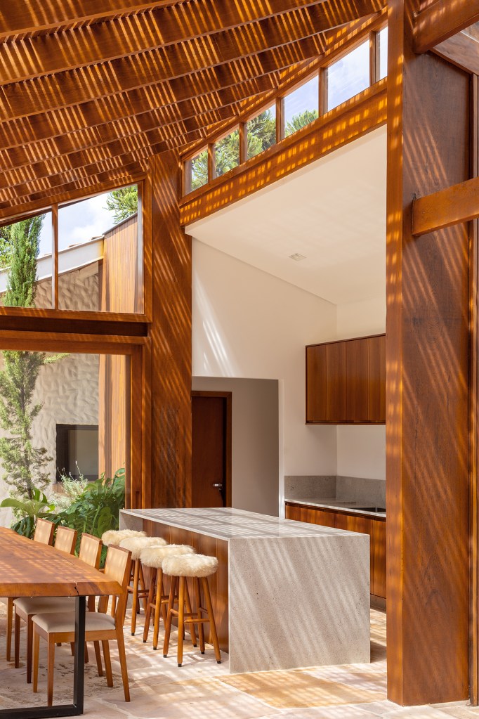 Anexo de 190m ² renova antiga casa em Campos do Jordão. Projeto Vaga Arquitetura. Na foto, varanda com espaço gourmet e estar.