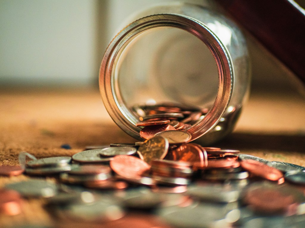 como-fazer-ritual-atrair-mais-dinheiro-josh-appel-unsplash Como fazer um ritual para atrair mais dinheiro. Na foto, pote vidro com moedas virado em mesa.