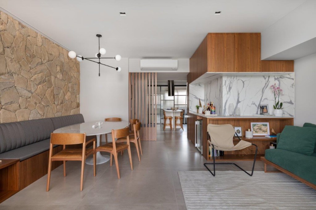 Cores verde, azul, rosa e detalhes em pedra e palha pontuam apê de 180 m²