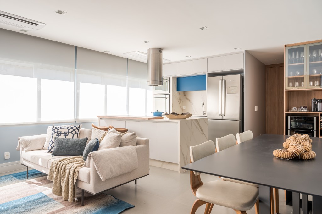 Tons de azul e integração total na área social marcam apê de 107 m²