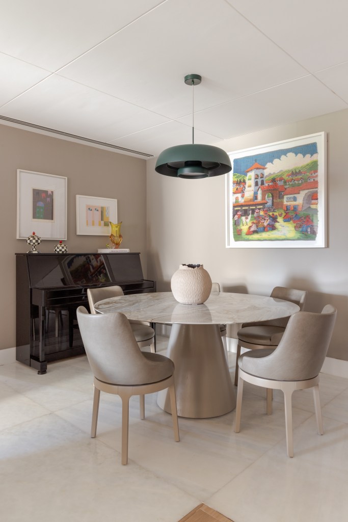 ape-150-m-cozinha-tom-verde-suave-estante-vazada-ana-cano-14-jantar Apê de 150 m² ganha cozinha em tom verde suave e estante vazada na sala. Projeto de Ana Cano. Na foto, sala de jantar, mesa redonda, cadeiras cinzas, piano.