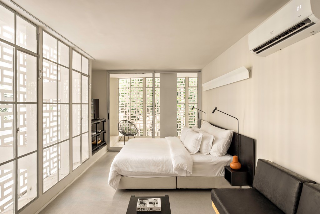 retrofit-predio-centro-sp-vence-monocle-design-awards-metro-arquitetos-credito-fran-parente (22) Retrofit de prédio no centro de SP vence Monocle Design Awards 2024. Projeto de Metro Arquitetos. Na foto, quarto com parede de cobogó e cama de casal.