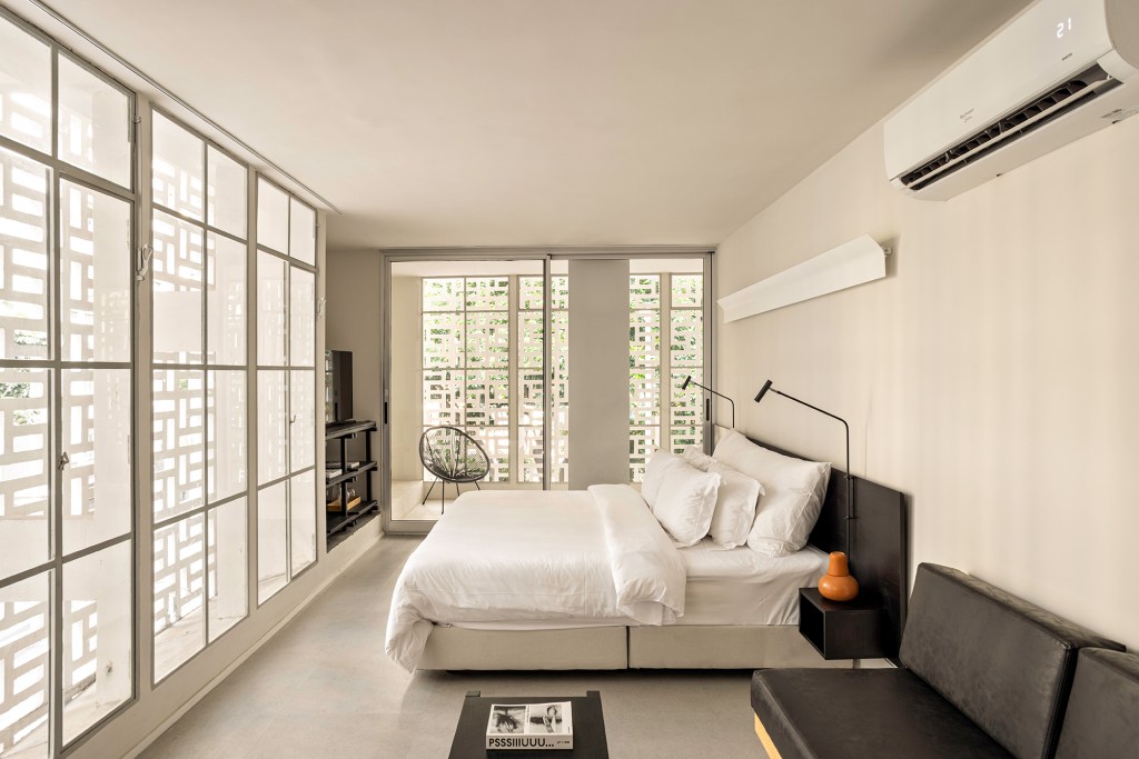 Retrofit de prédio no centro de SP vence Monocle Design Awards 2024. Projeto de Metro Arquitetos. Na foto, quarto com parede de cobogó e cama de casal.