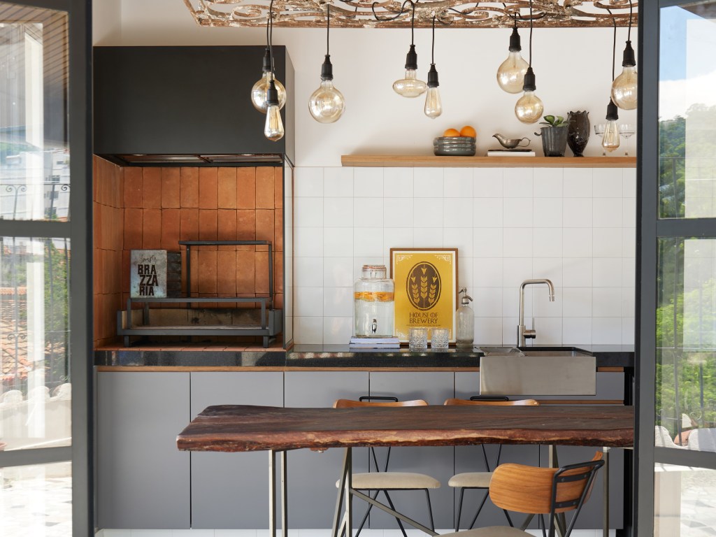 Porta de serralheria vira luminária pendente em cobertura com parrilheira