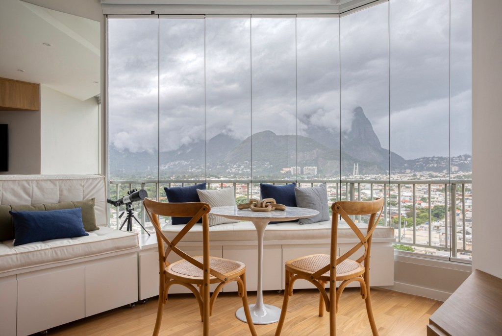 Apartamento-de-90-m2-apresenta-design-com-toques-praianos-11-janela Apartamento de 90 m² apresenta design com toques praianos. Projeto do escritório Memoá Arquitetos. Na foto, sofá e poltrona em tons Apartamento de 90 m² apresenta design com toques praianos. Projeto do escritório Memoá Arquitetos. Na foto, sala de jantar com janela extensa