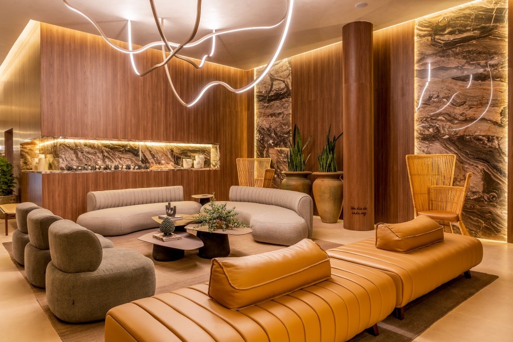 Pedras de diferentes tons revestem paredes e nichos em sala de estar