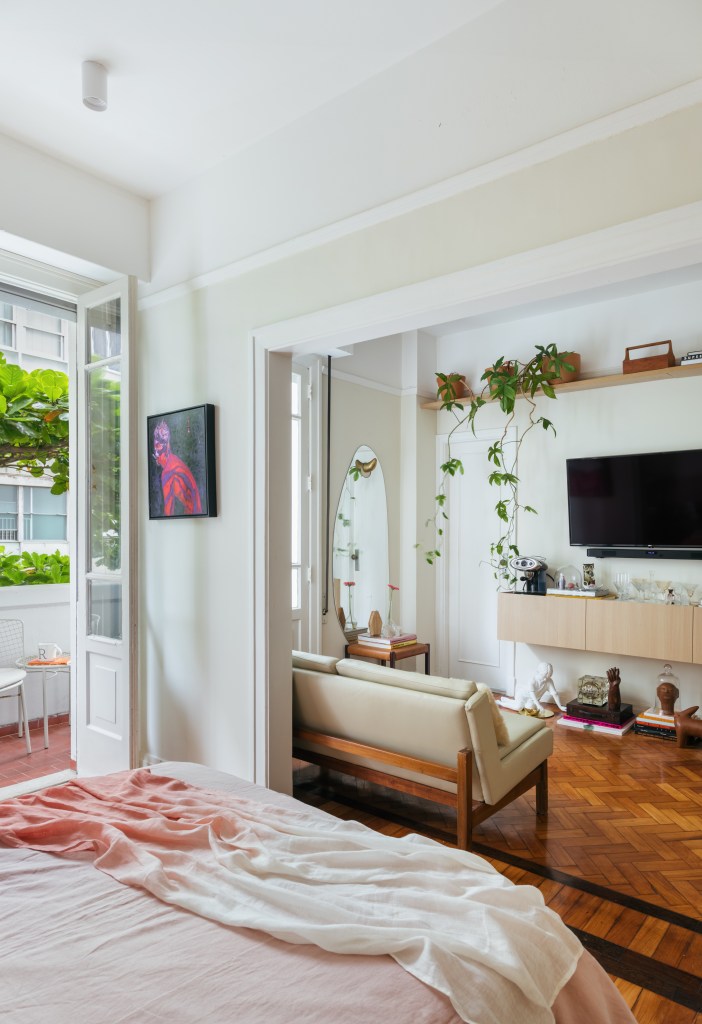 Apê de 42 m² em tons de branco e bege tem sala e quarto integrados. Projeto de Rodolfo Consoli. Na foto, sofá pequeno, porta de correr, varnada.